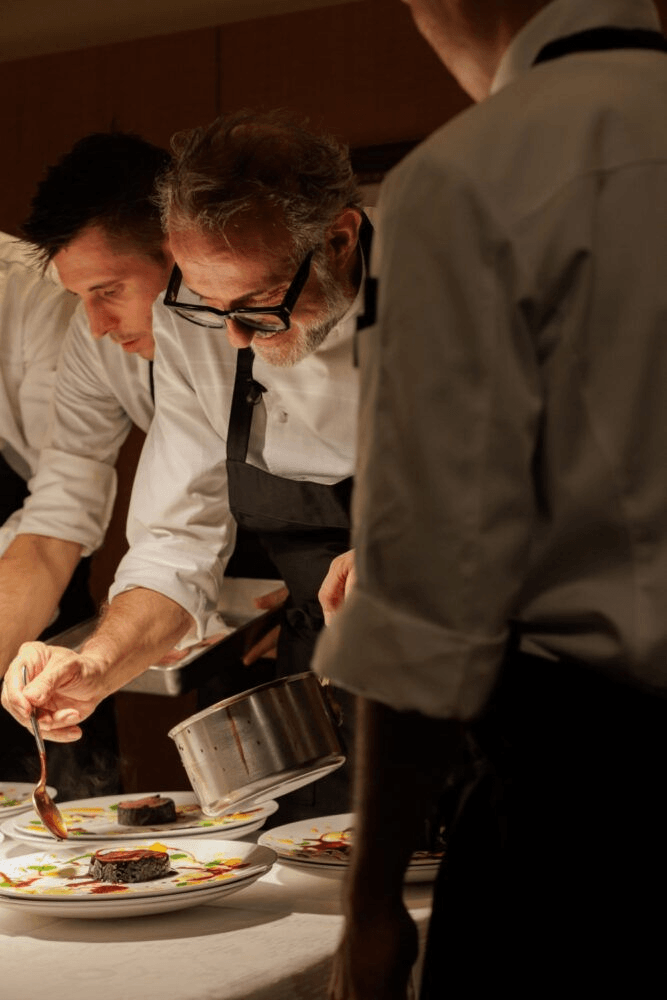 Chefs plating a caviar course in the kitchen
